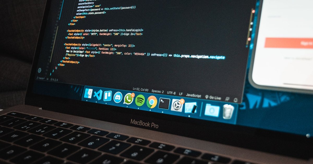 Laptop mostrando codigo de programacion en un escritorio de trabajo moderno