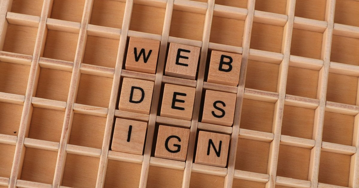 Bloques de madera formando la frase web design sobre fondo de cuadricula